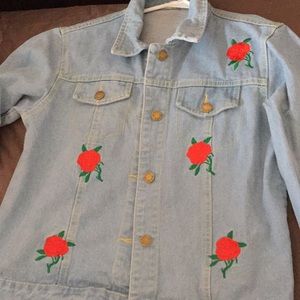 Denim jacket with red rose detailing.